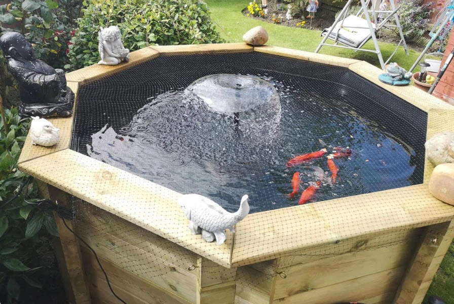 Wooden koi pond kit in a beautiful Cornwall garden, coastal landscape backdrop.